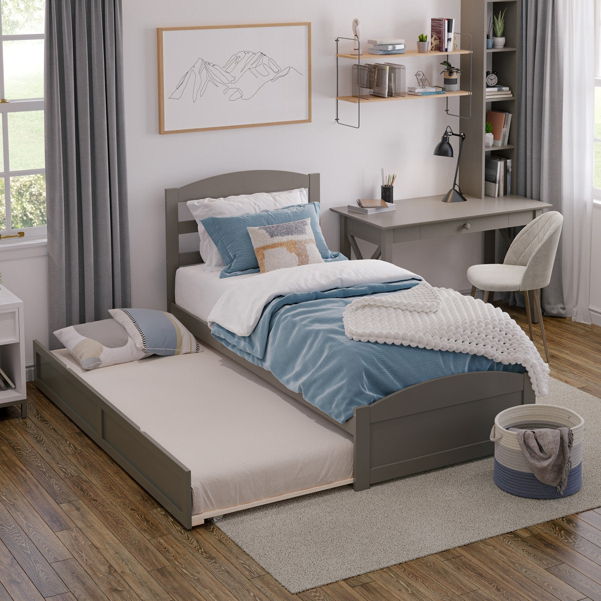 Bedroom with a gray bed, desk, and chair, and decorative elements.