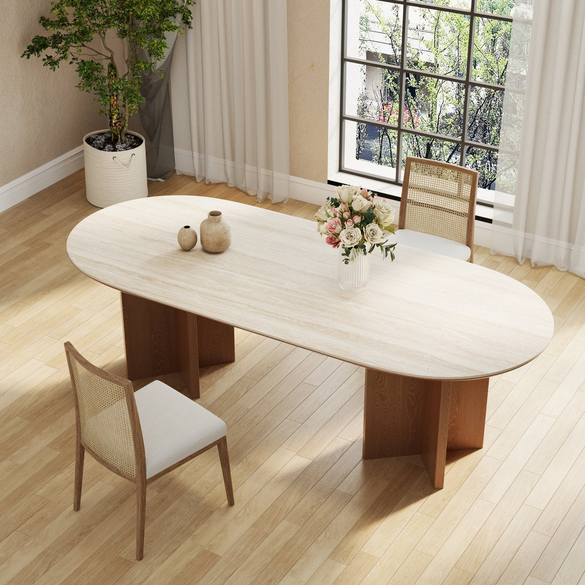 Dining room with a large oval wooden table and chairs, decorated with flowers and vases.