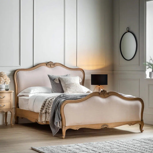 A luxurious vintage-style upholstered bed with a wooden frame and beige fabric headboard, situated in a well-appointed bedroom setting.