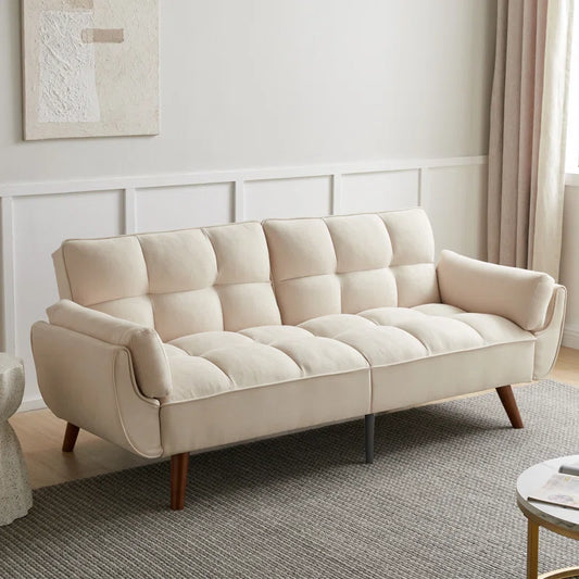 A modern beige 3-seater sofa with tufted backrest and wooden legs, situated in a room with light decor.