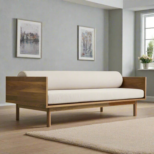 Wooden sofa with white cushions in a room with gray walls and a window.