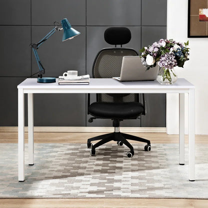 Modern office desk with laptop, lamp, and flowers in a stylish room.