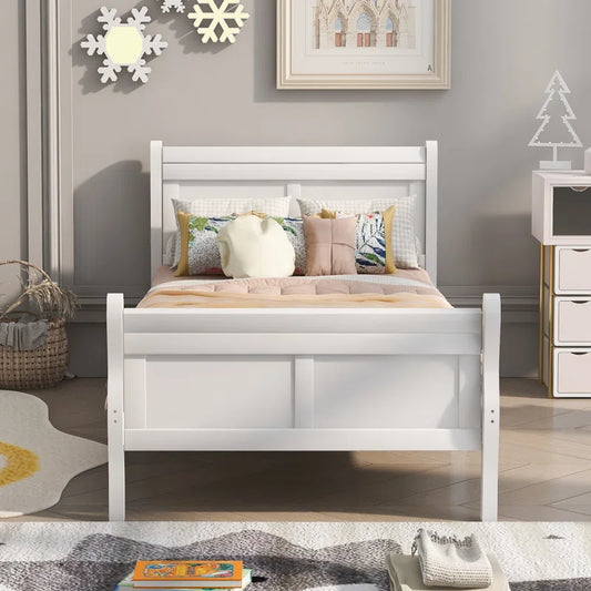 A white, handcrafted solid sheesham wood standard bed for kids with a mattress, pillows, and a decorative tree lamp on the nightstand in a bedroom setting.