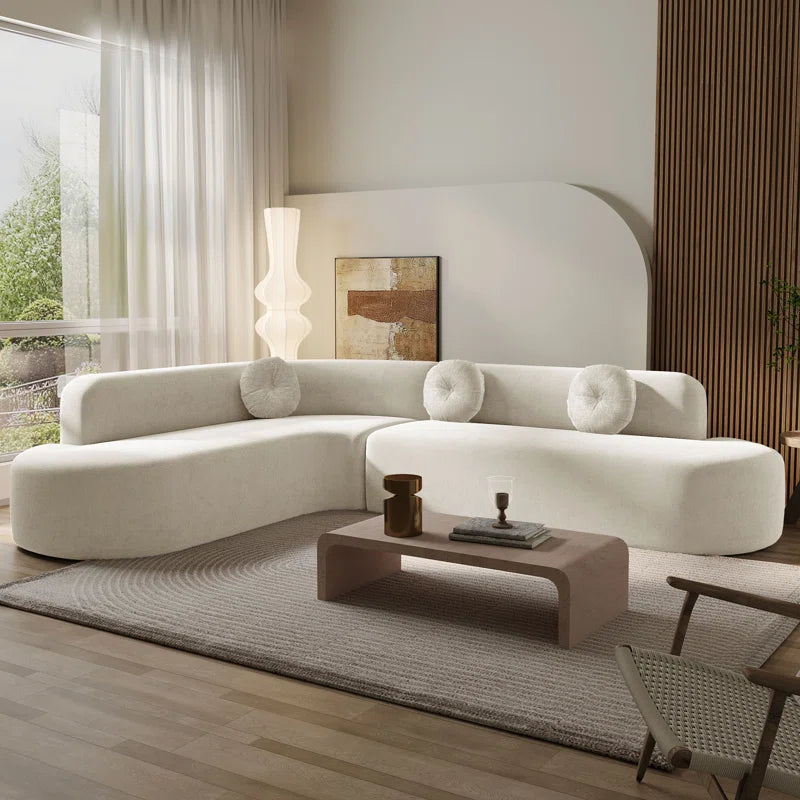Modern living room with a white sectional sofa, coffee table, and decorative items.
