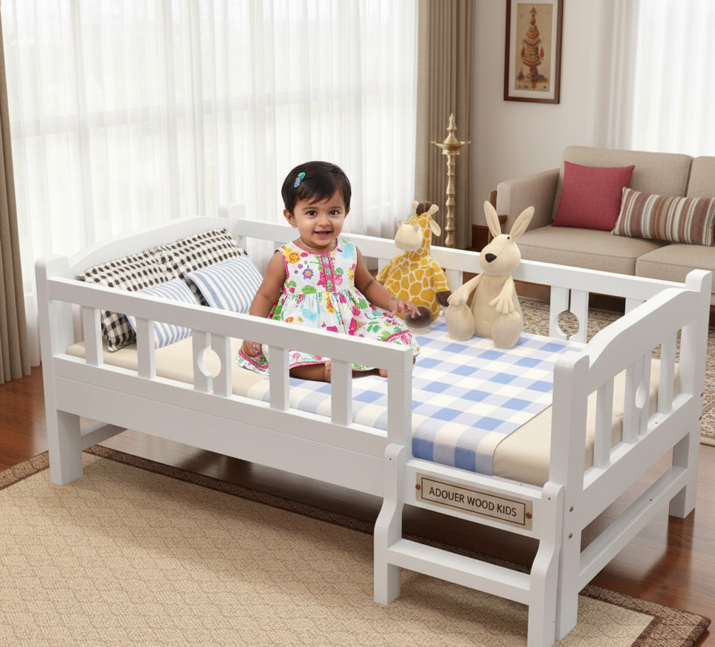 Child sitting on a white toddler bed in a room with toys and furniture.
