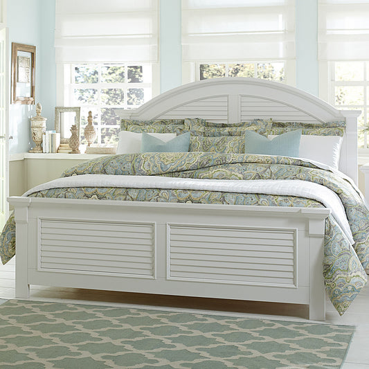 A white wooden panel bed with arched headboard, placed in a bedroom setting with floral bedding and a blue rug.