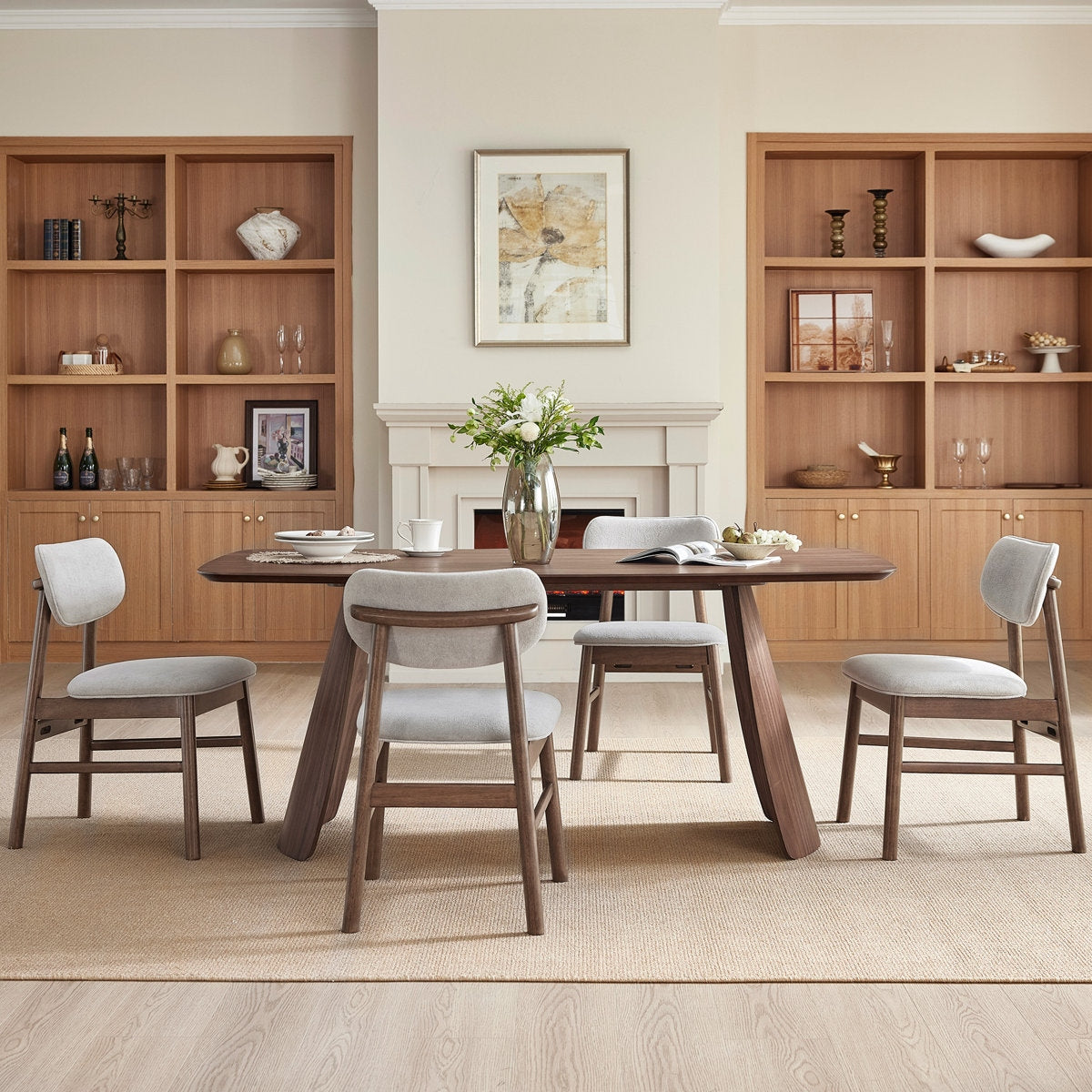 Dining room with wooden table and chairs, bookshelves, and a fireplace.