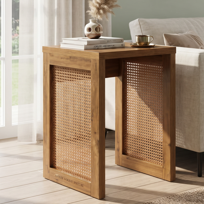 A wooden side table with woven cane panels, styled in a bright living room next to a sofa with books and a cup on top.