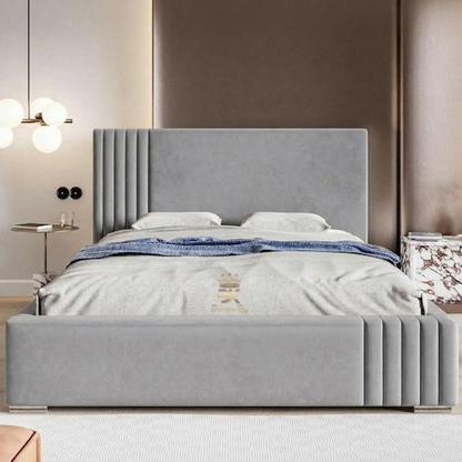 Gray upholstered bed in a bedroom setting with a headboard and bedding.