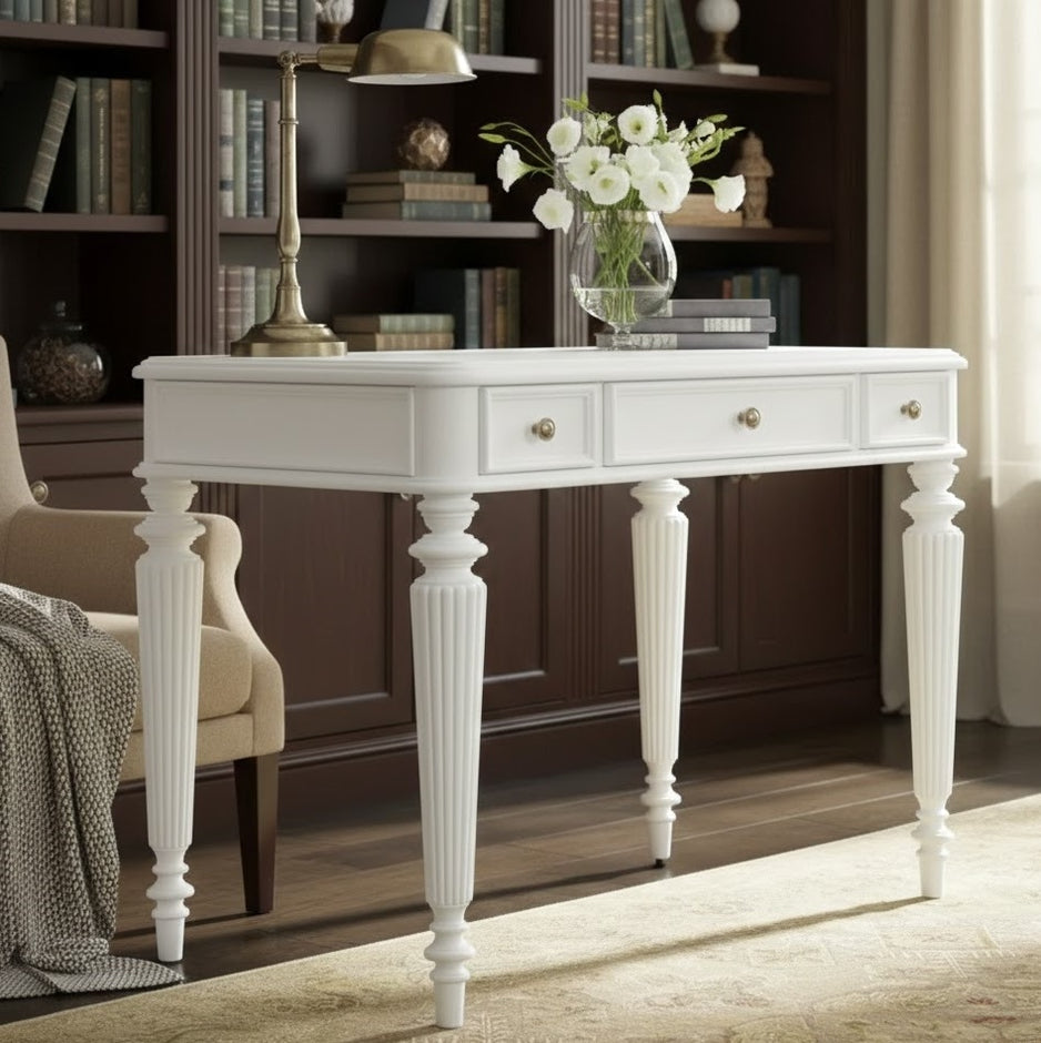 White console table with drawers in a room with bookshelves and a chair.
