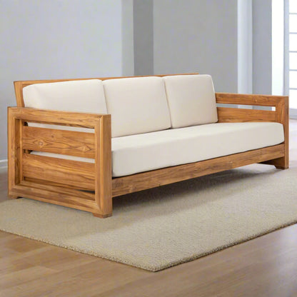 Wooden sofa with white cushions on a neutral background
