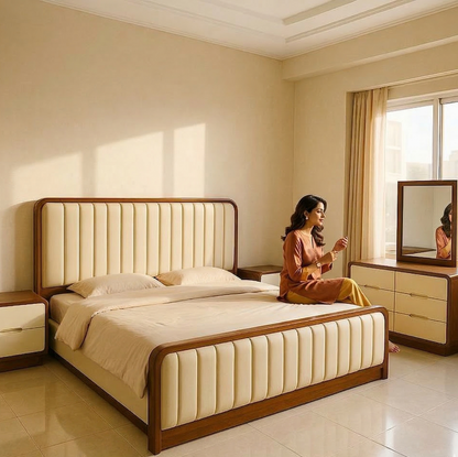 Woman sitting on a bed in a well-lit bedroom with beige walls and furniture.