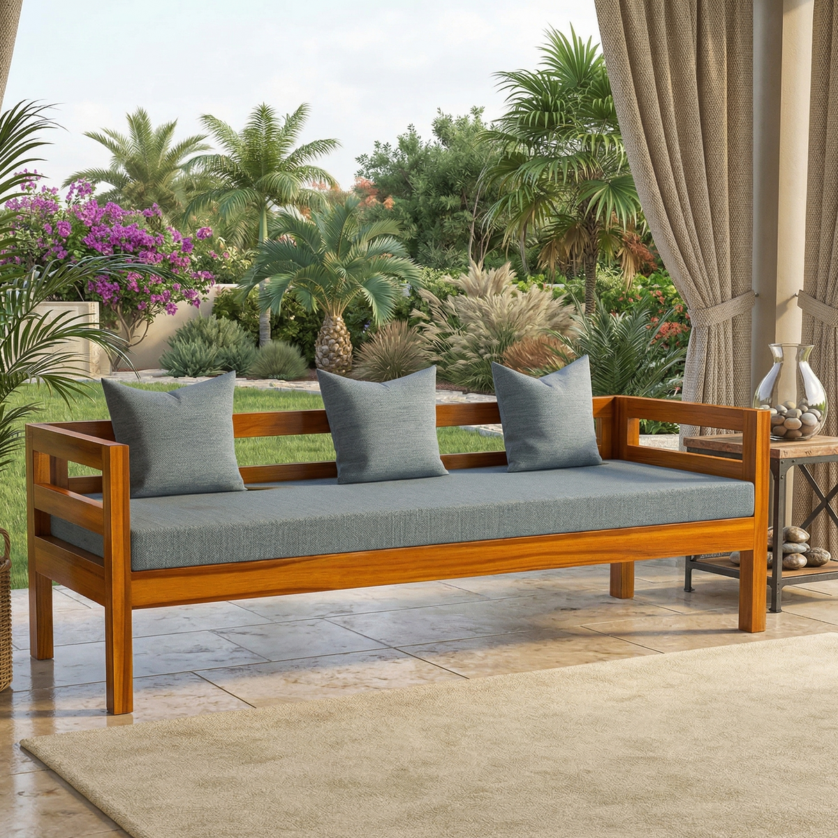 Wooden bench with gray cushions on a patio with plants and flowers in the background