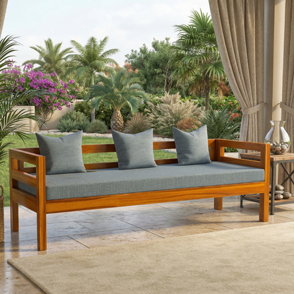 Wooden bench with gray cushions on a patio with plants and flowers in the background