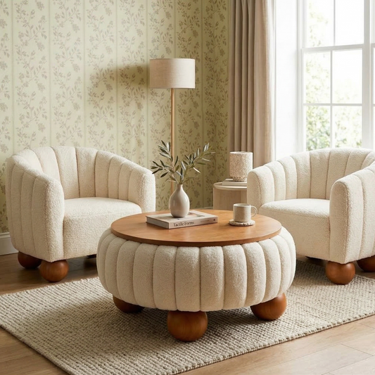 Living room with two cream-colored armchairs and a round ottoman table.